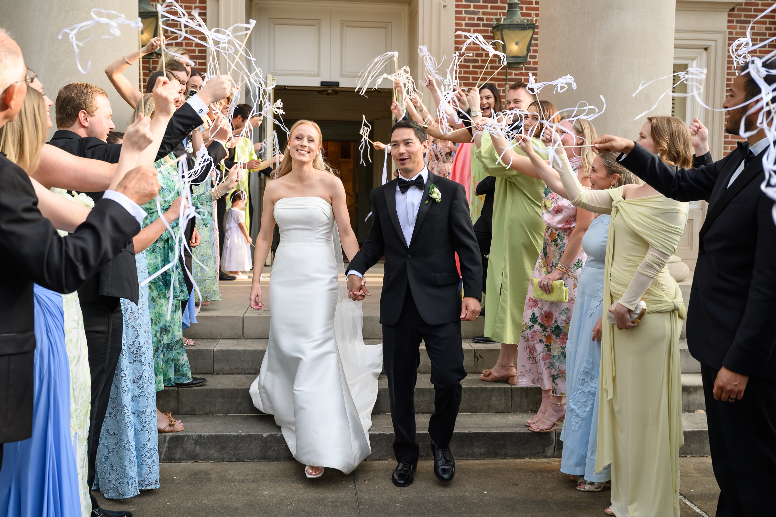 Bride and groom walk through a celebratory exit outside La Colombe d’Or in Houston