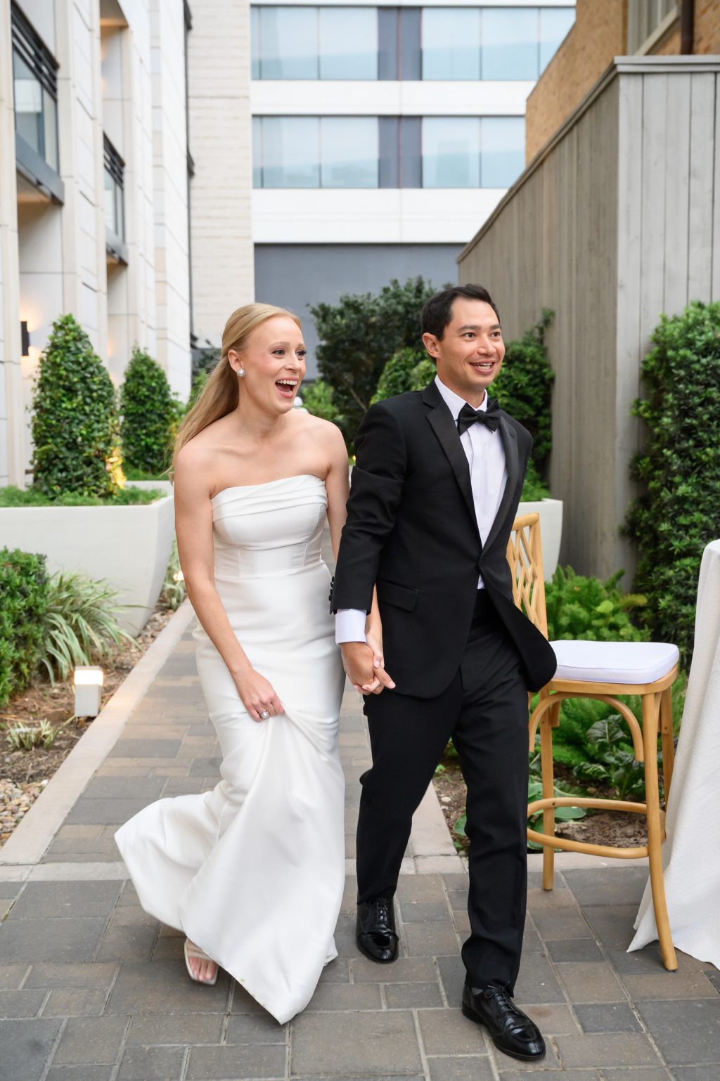 Bride and groom walking together through the courtyard at La Colombe d’Or in Houston