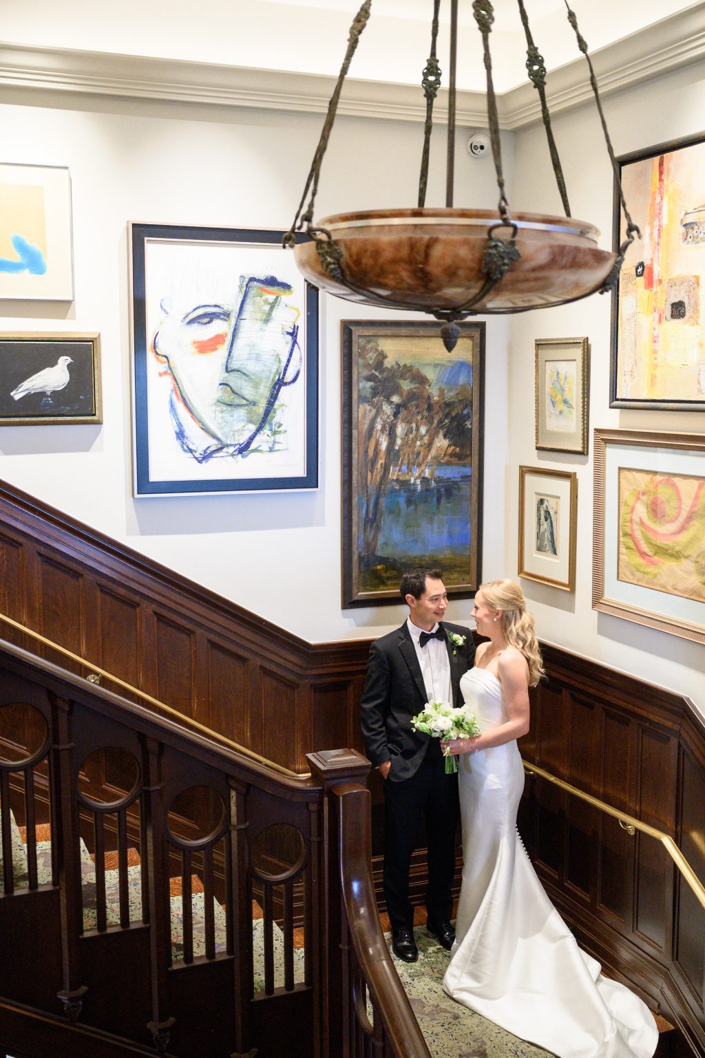 Bride and groom photographed on the art-filled staircase inside La Colombe d’Or