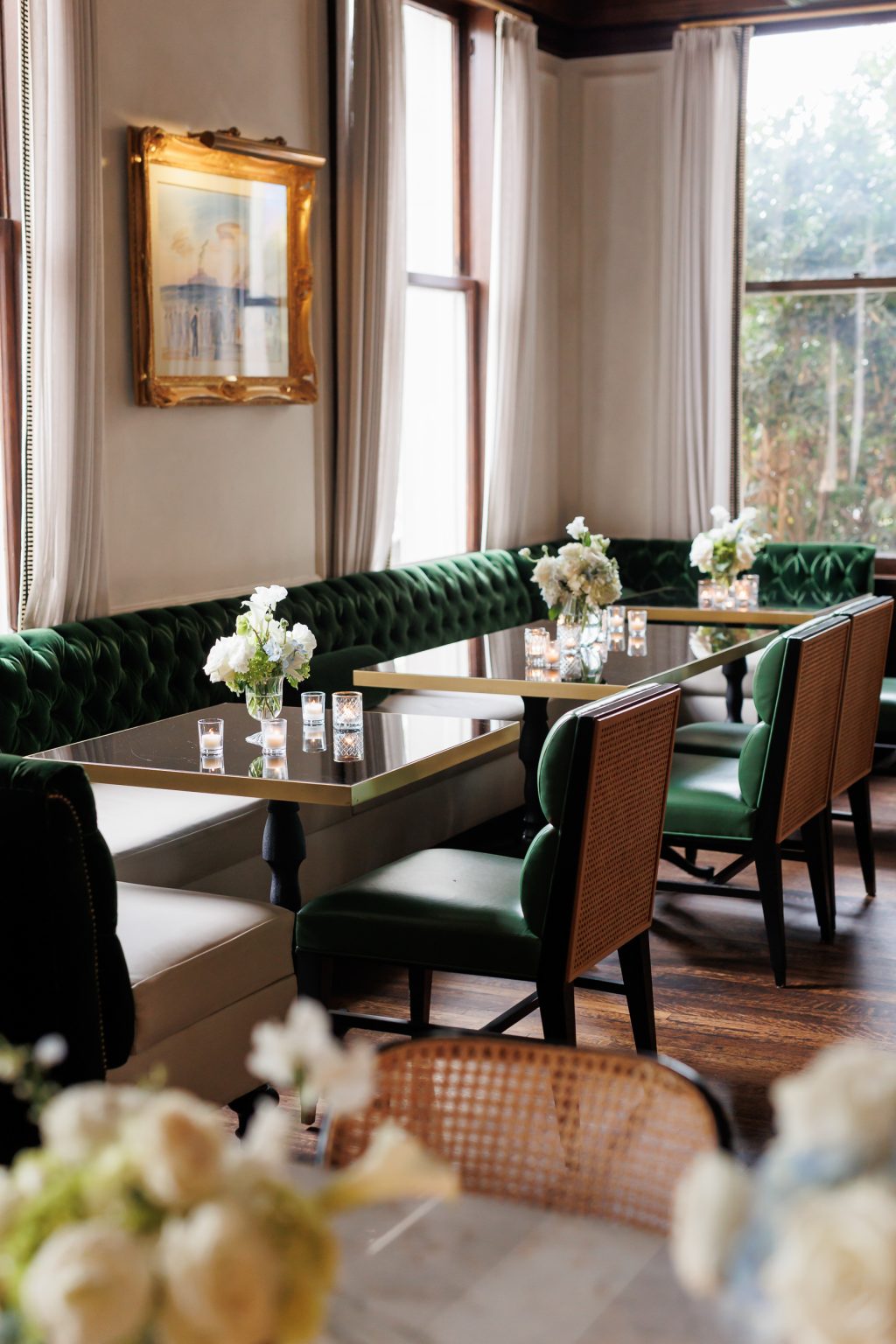 Green banquette seating and wedding table details inside La Colombe d’Or in Houston