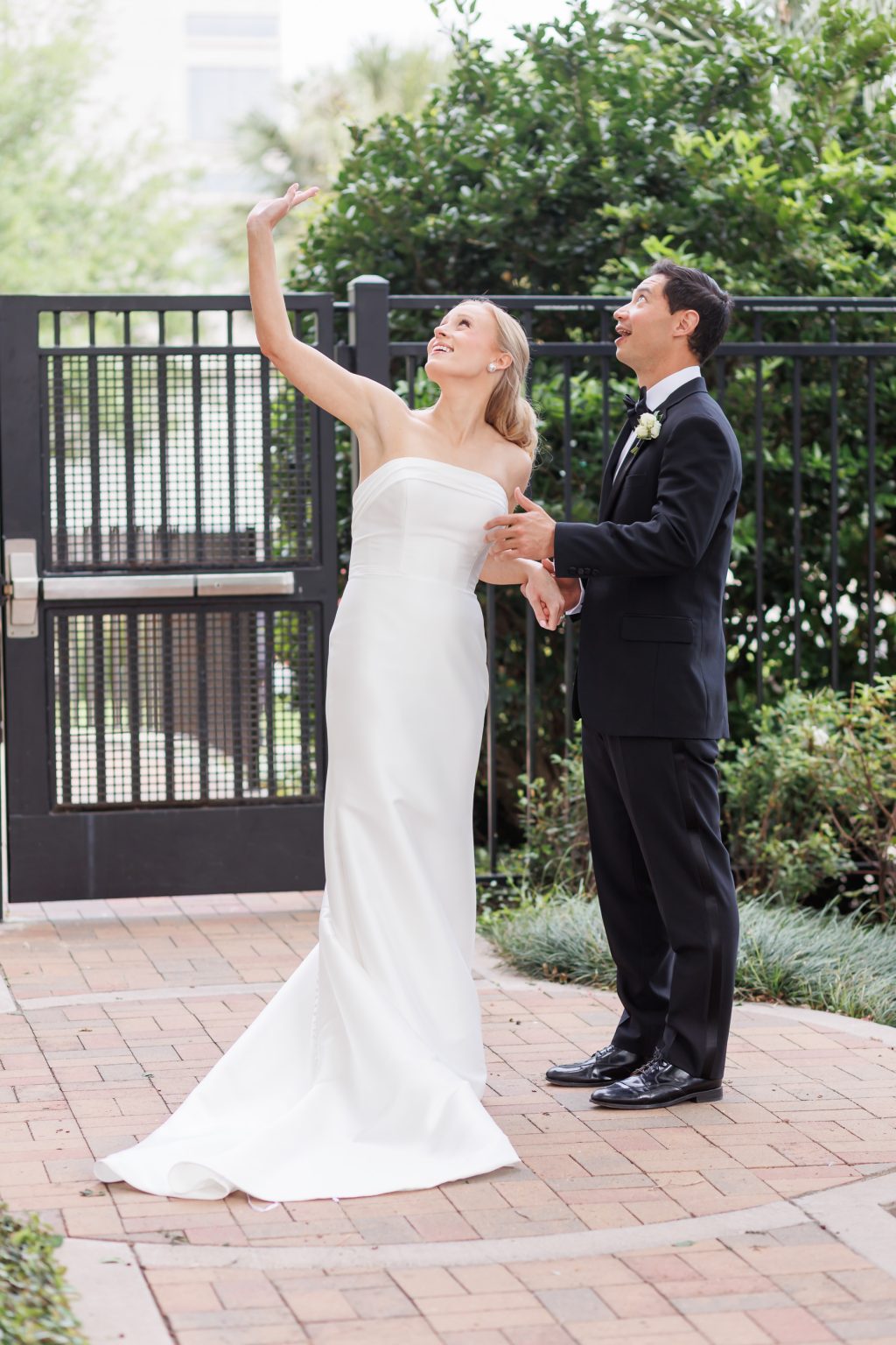 Bride and groom sharing a playful moment in the courtyard at La Colombe d’Or