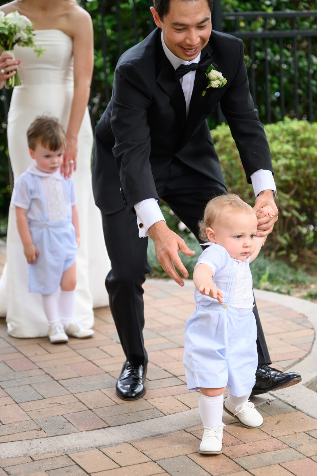 Groom interacting with two young wedding guests during the celebration in Houston
