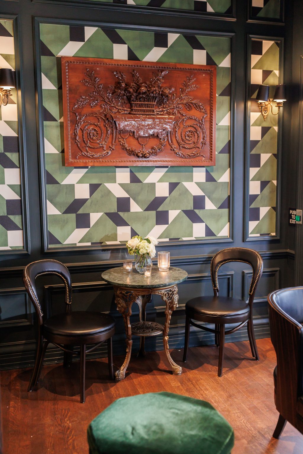 Colorful artwork, patterned walls and lounge seating inside La Colombe d’Or in Houston