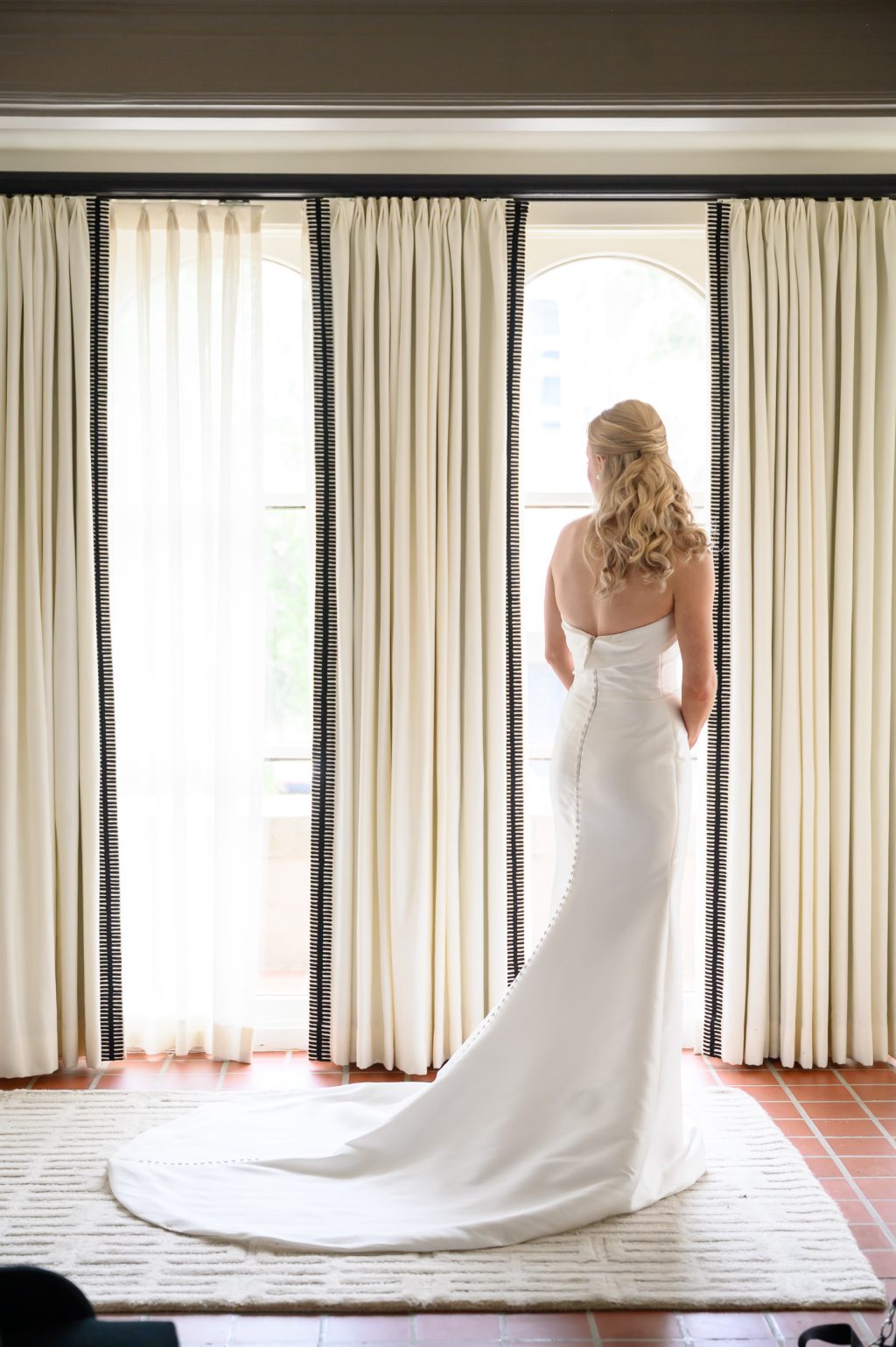Bride standing by tall windows inside the historic La Colombe d’Or mansion