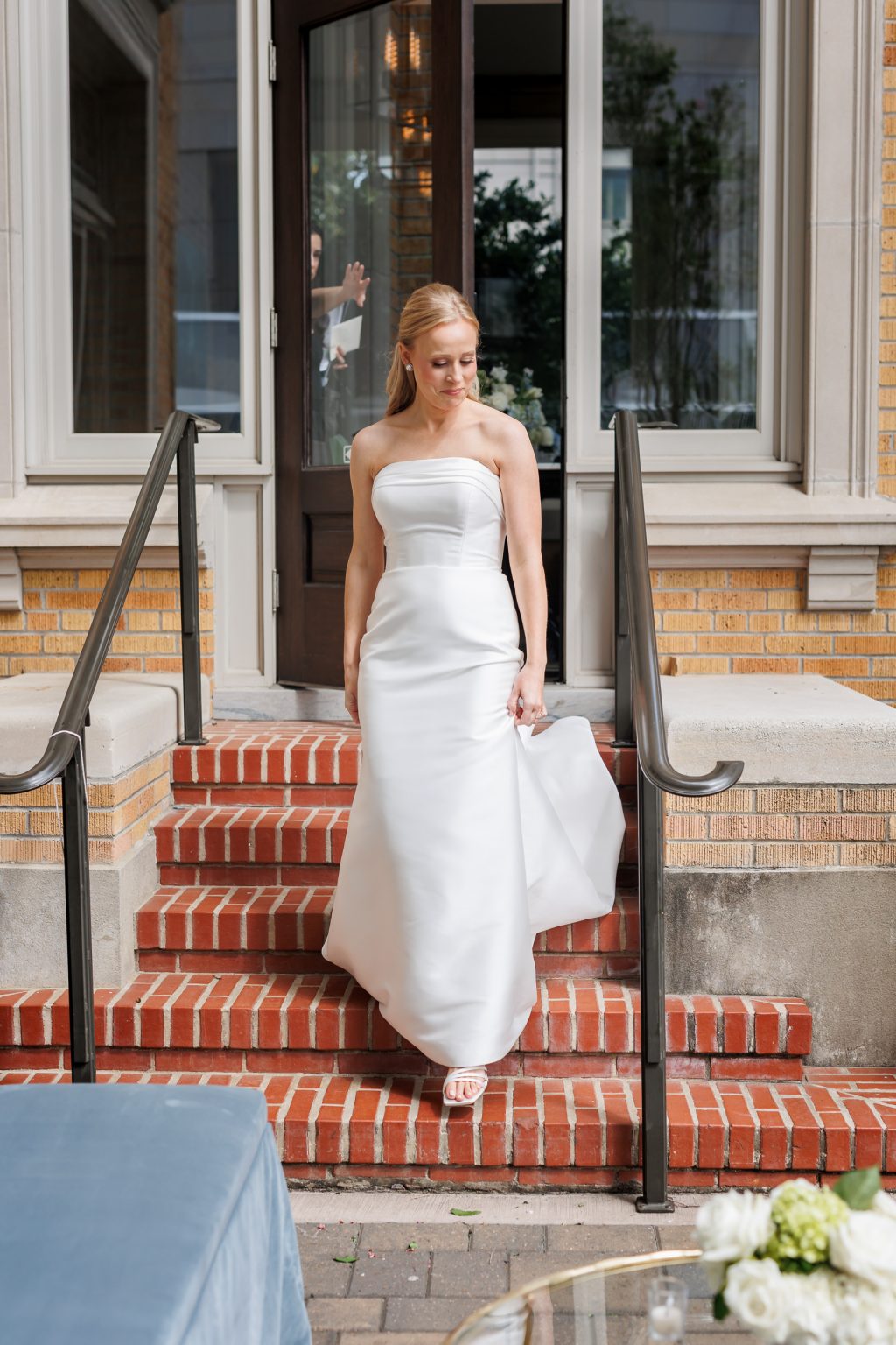 Bride walking down the brick steps outside La Colombe d’Or in Houston