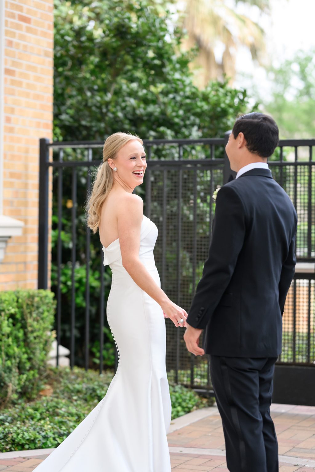 Bride smiling at the groom during their first look at La Colombe d’Or in Houston