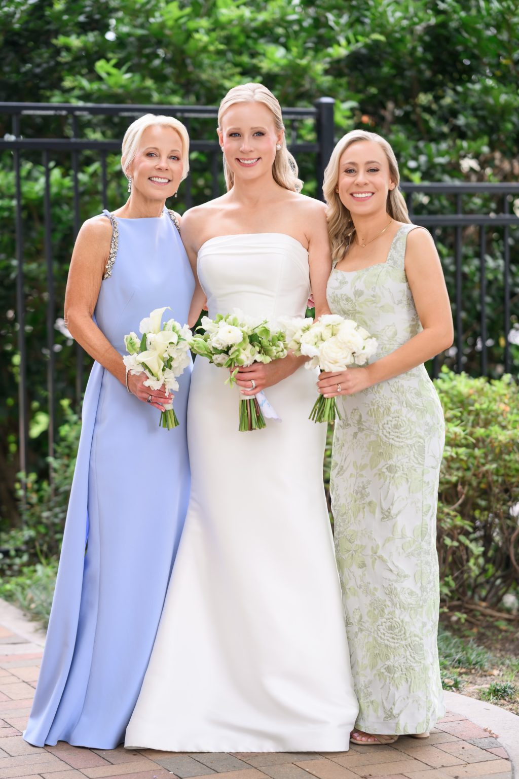 Bride photographed with her mother and sister in soft blue and green dresses at La Colombe d’Or