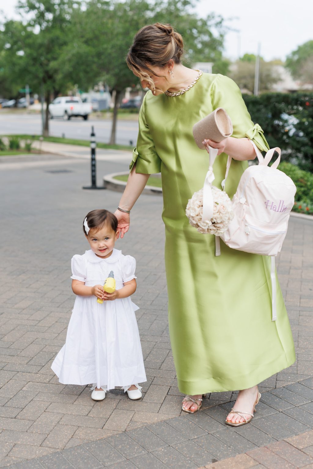Flower girl walking with an adult before the church ceremony in Houston