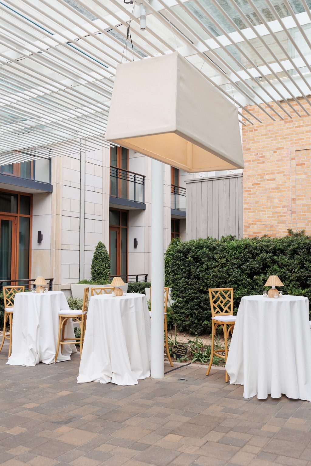 Cocktail tables and modern overhead lighting set in the La Colombe d’Or courtyard
