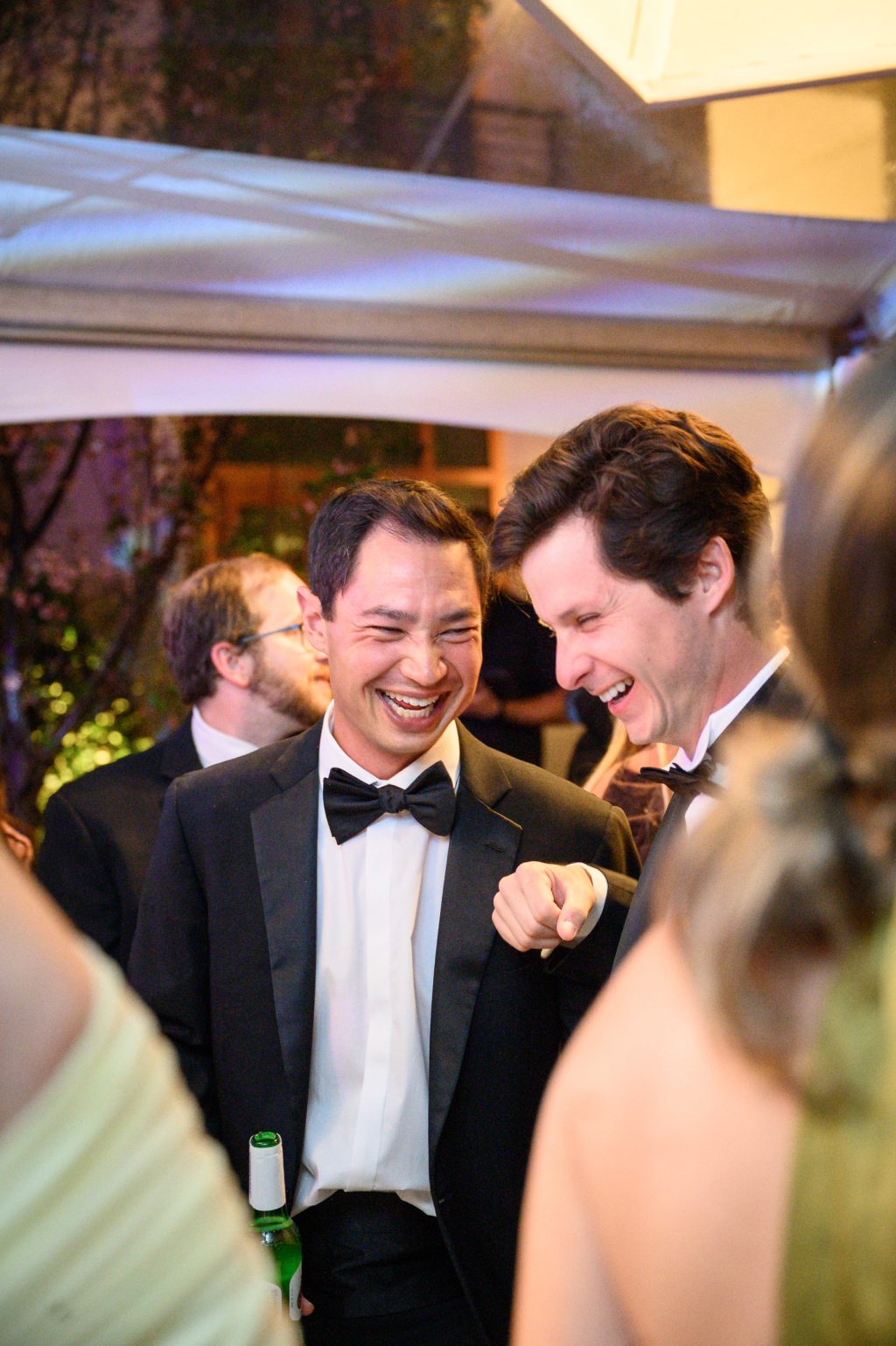 Groom laughing with friends during the La Colombe d’Or wedding reception