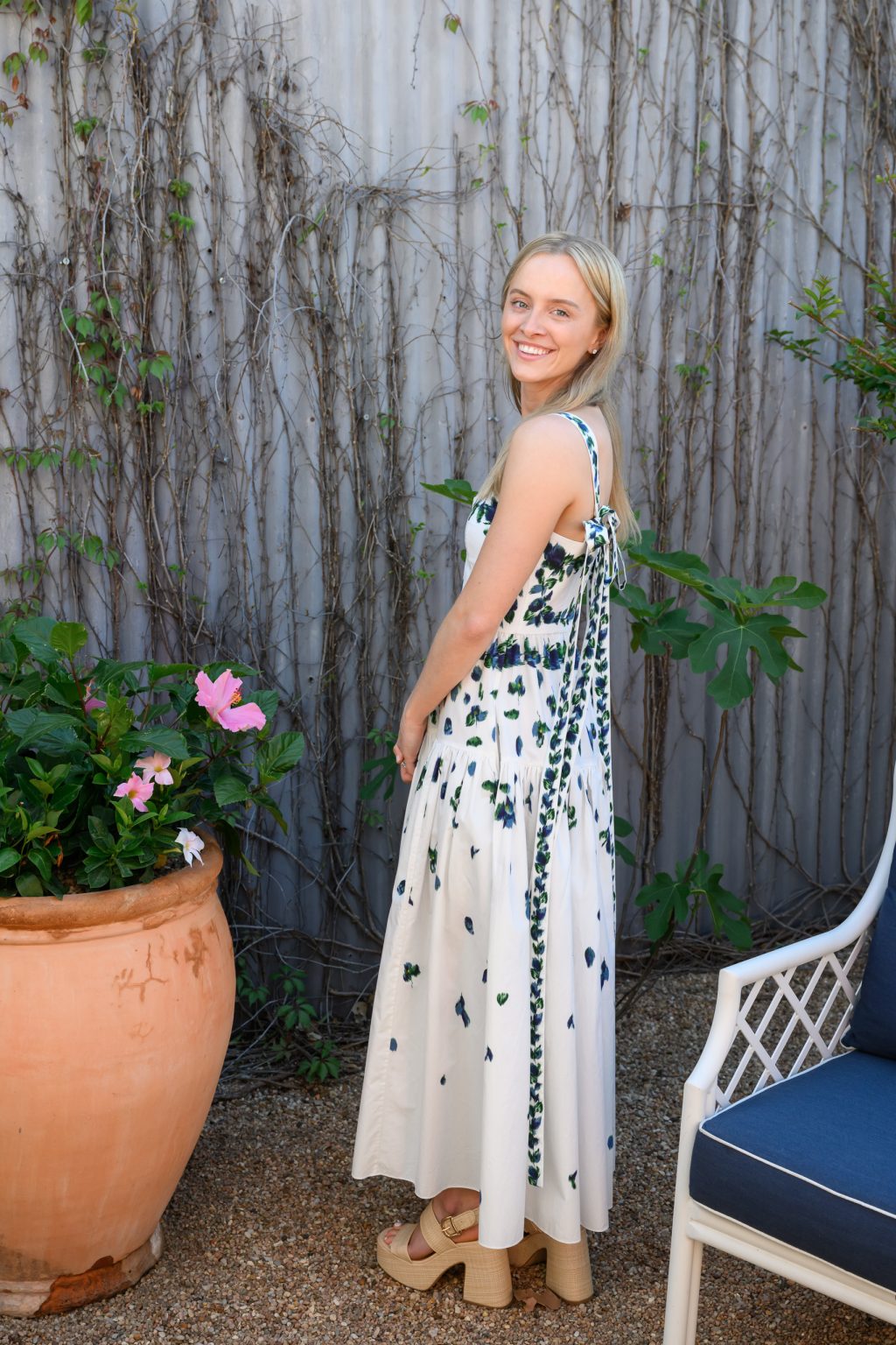 Sara posing outside Elizabeth Street Cafe in a white and blue floral dress before her bridal luncheon.