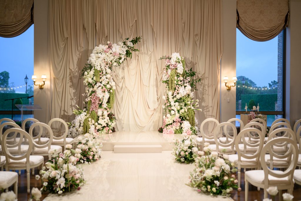 Indoor wedding ceremony at River Oaks Country Club with soft draping and floral arrangements