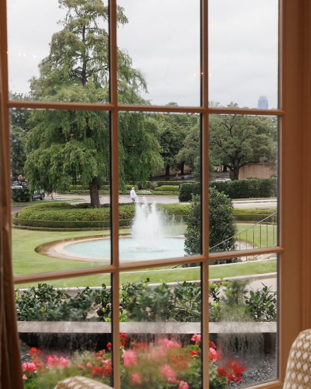 Rainy view of the River Oaks Country Club fountain through a large interior window