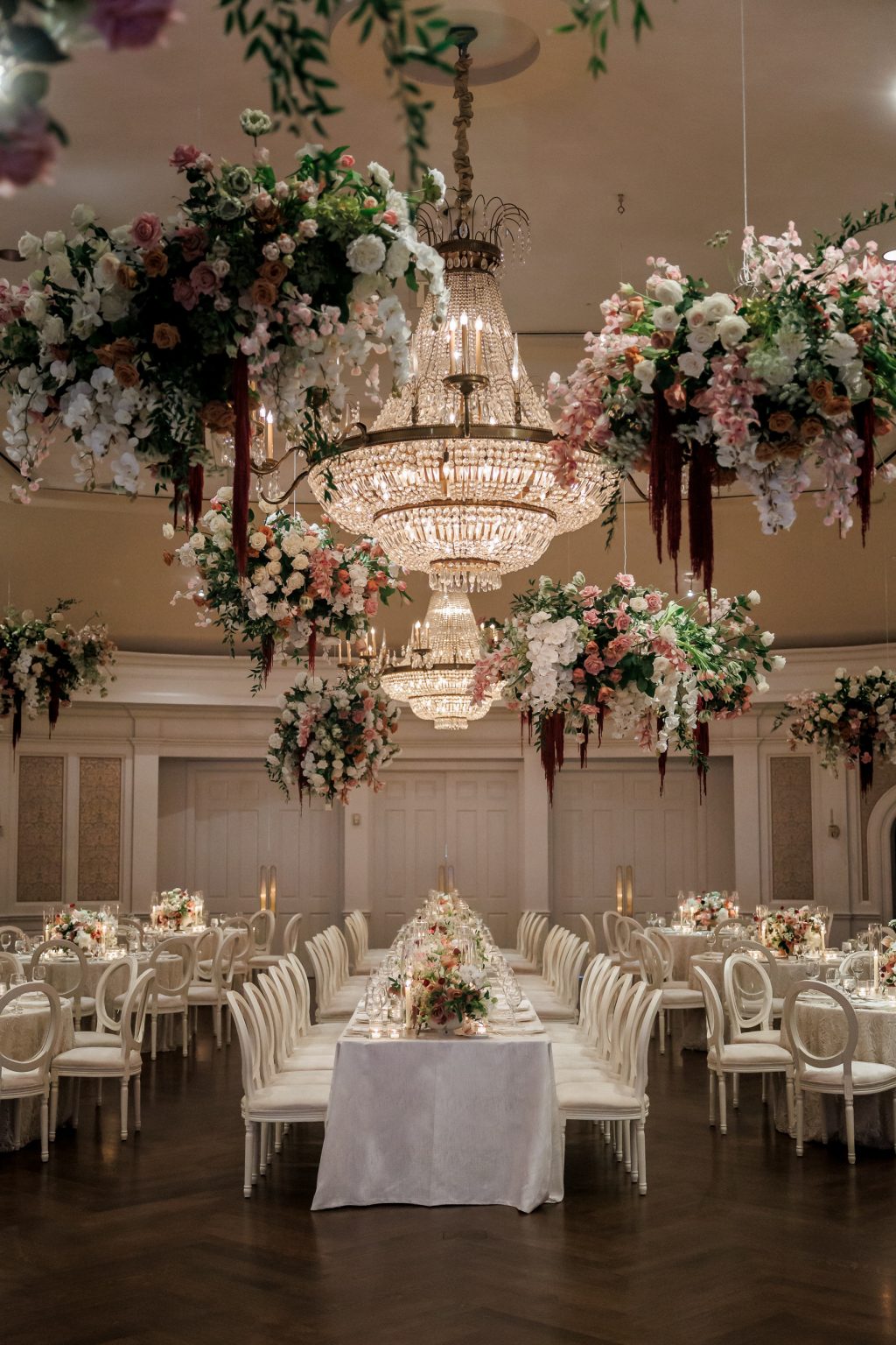 Hanging floral installations surrounding a chandelier in the River Oaks Country Club Grand Ballroom by Blooming Gallery