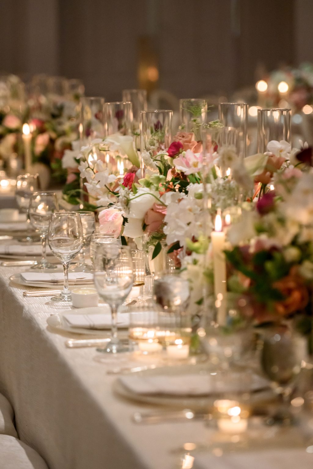 Candlelit wedding tablescape with colorful floral arrangements at River Oaks Country Club